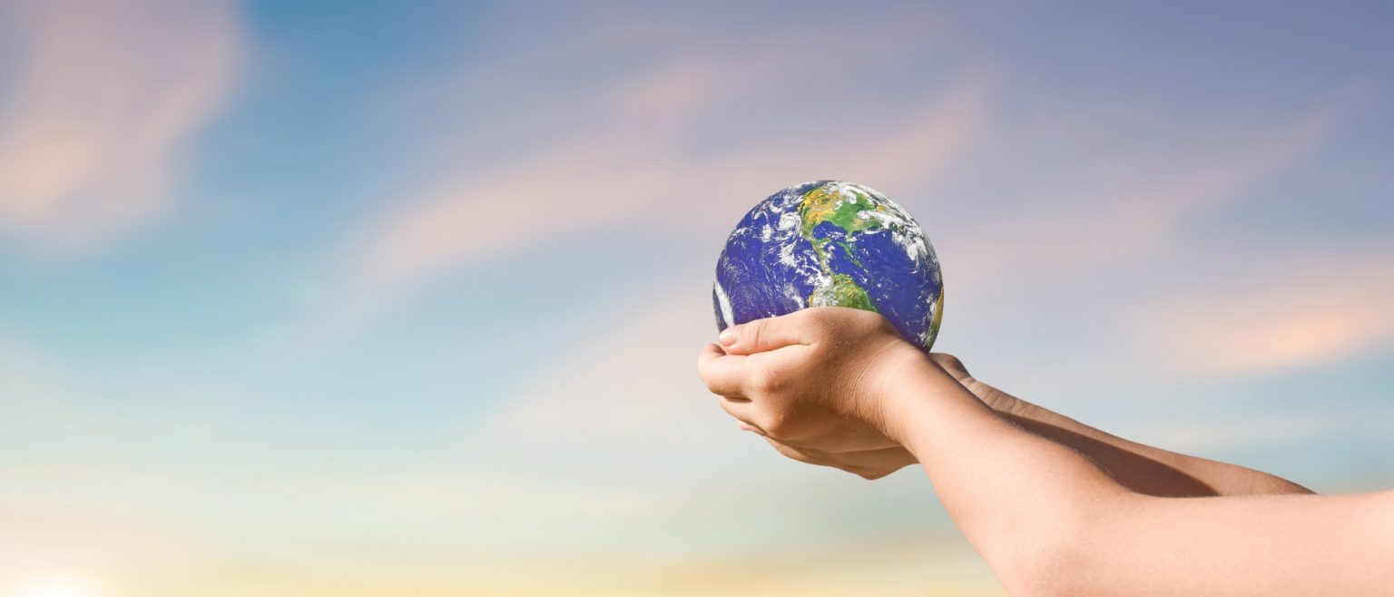 environment day concept, Globe in child hands over blue sky background environment day concept, Globe in child hands over blue sky background